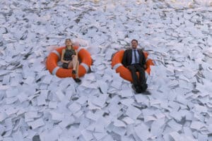 two people floating in a sea of papers on life rafts